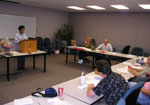 photo of Melanie speaking at a meeting with other Softalkers looking on